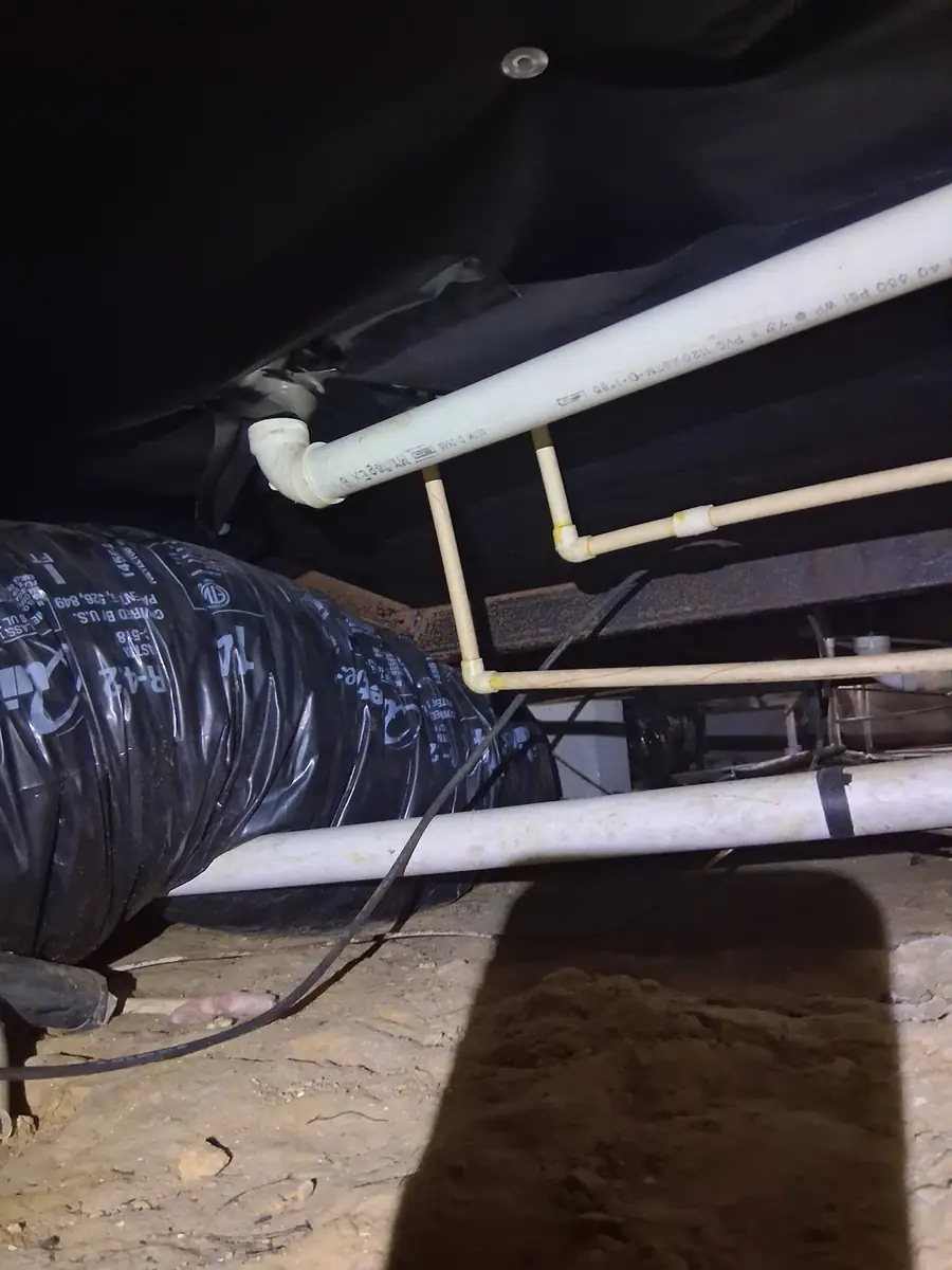 White drain lines and a black wrapped duct under black belly wrap