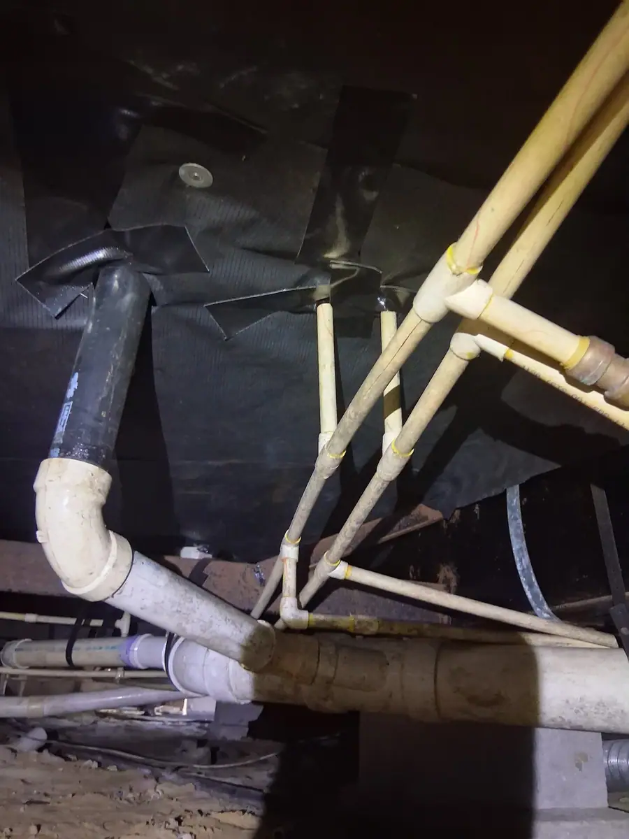 PVC and black drain lines hung under black belly wrap