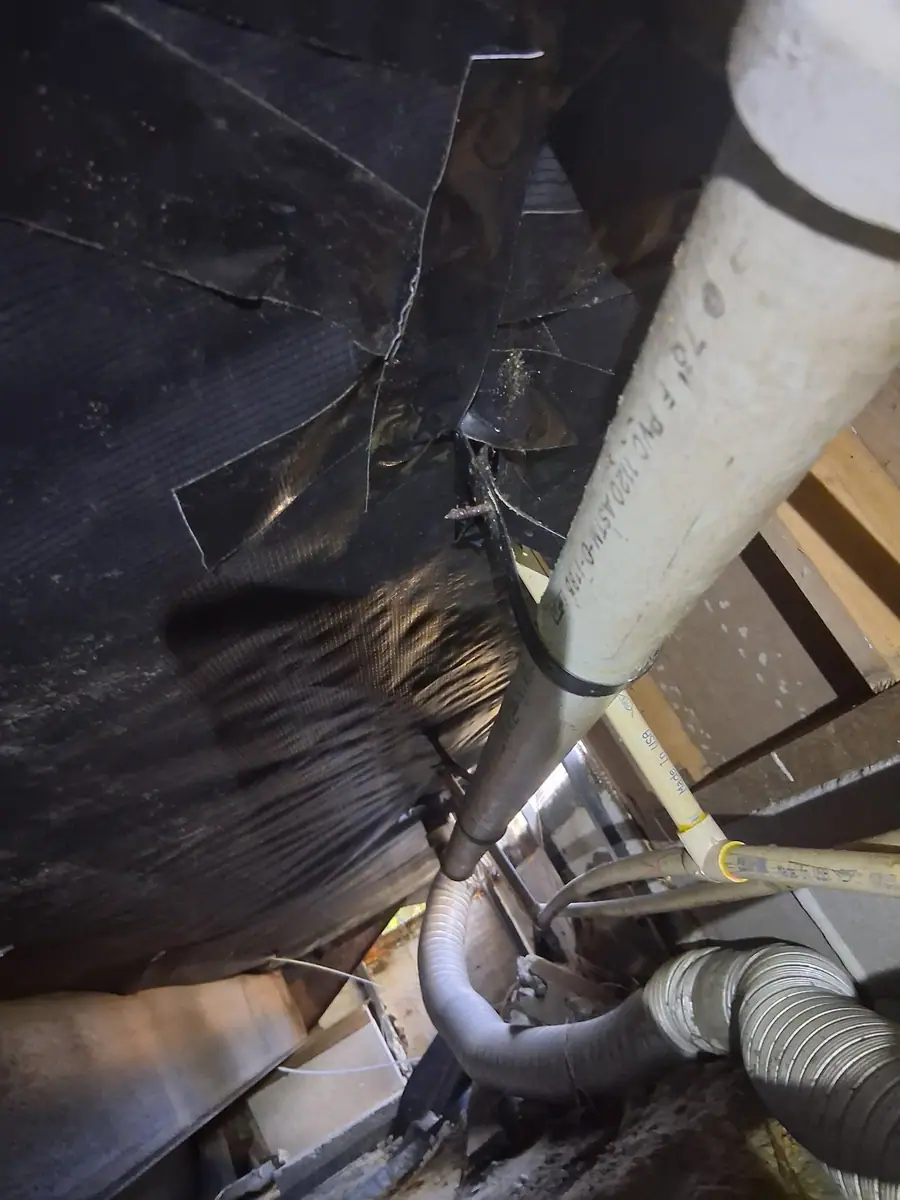 Torn belly wrap around a large drain pipe and flex ducts