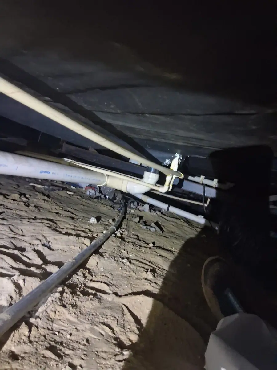 PVC lines hung under black belly wrap over bare dirt