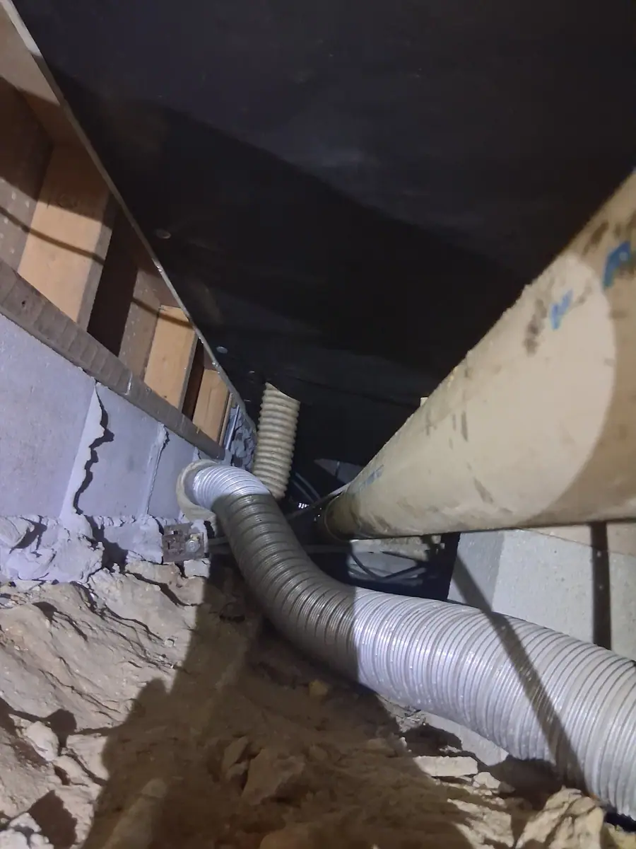 Flex duct and a large drain pipe under the belly of a manufactured home
