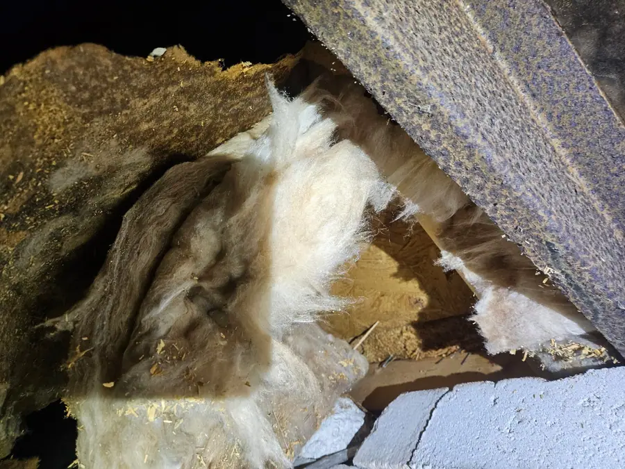 Insulation sagging through a hole beside the steel beam