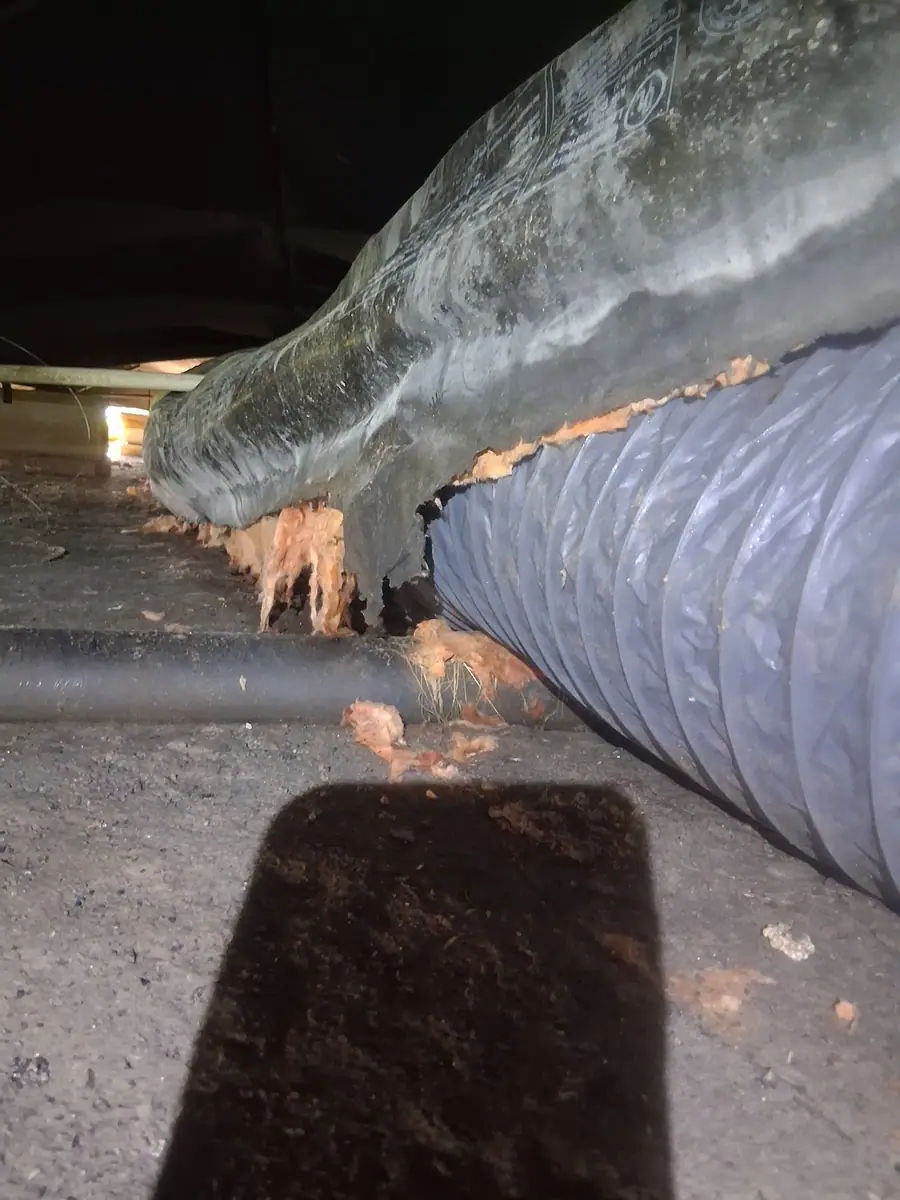 Torn belly sagging onto a flex duct, insulation hanging out