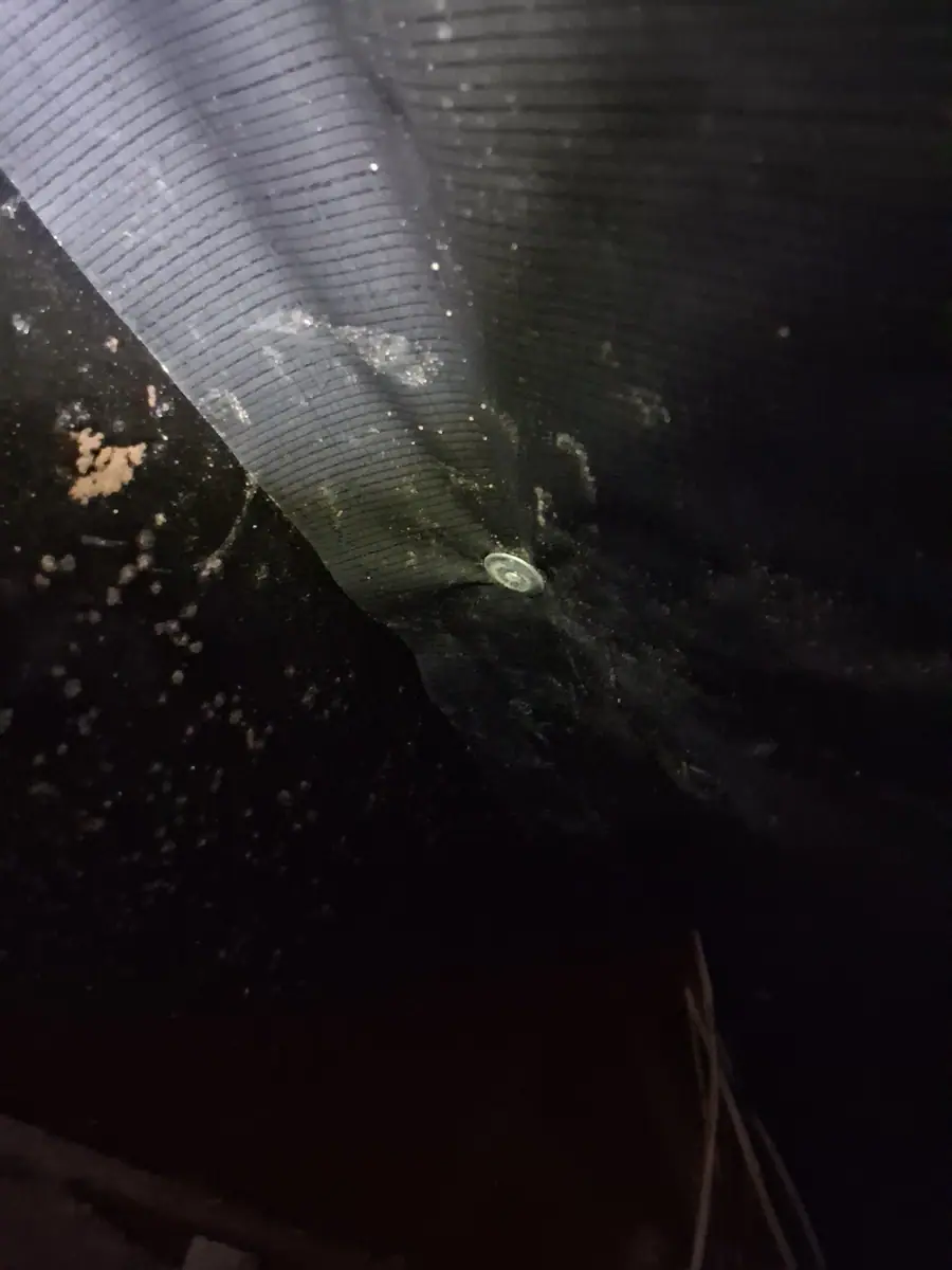 Black belly wrap fastened under the floor of a manufactured home