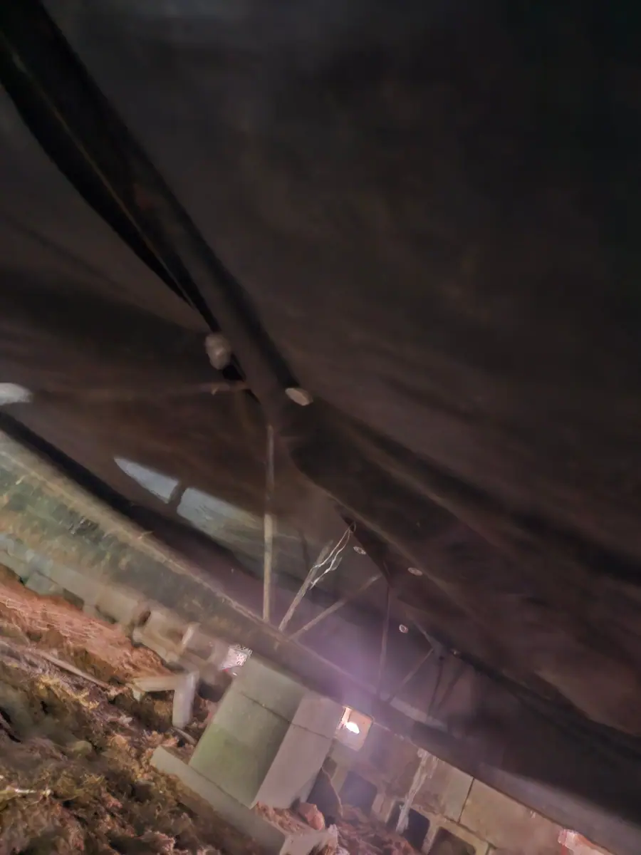Black belly wrap fastened down the length of the crawl space
