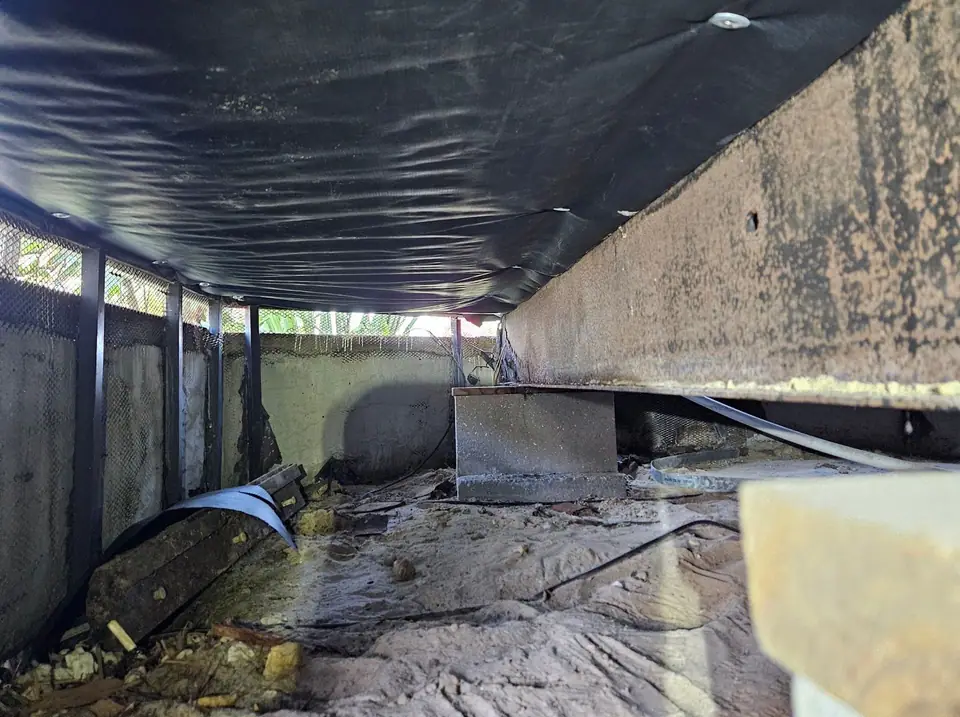 Inside a finished crawl space under new black belly wrap