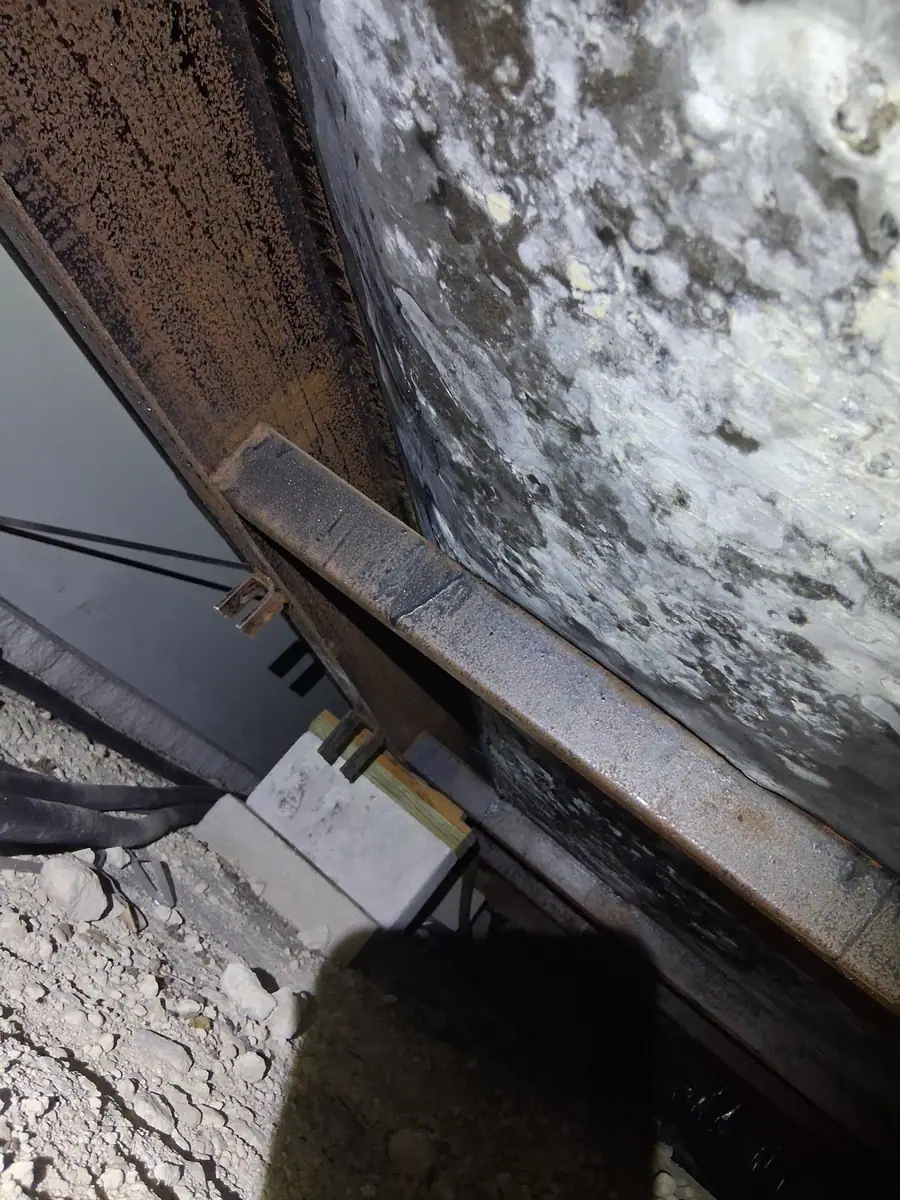 Mold-stained bottom board beside the steel I-beam and a block pier