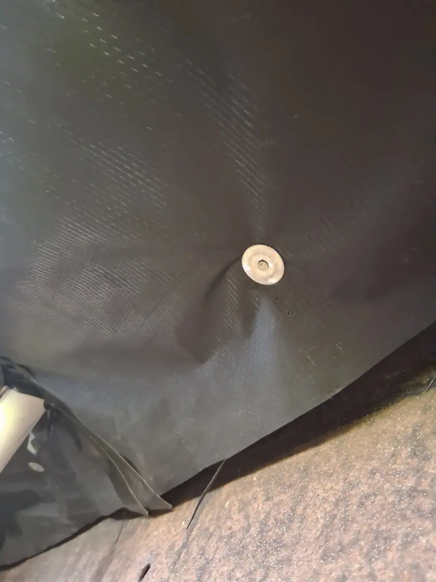 New black belly wrap fastened under a manufactured home floor with a round washer fastener