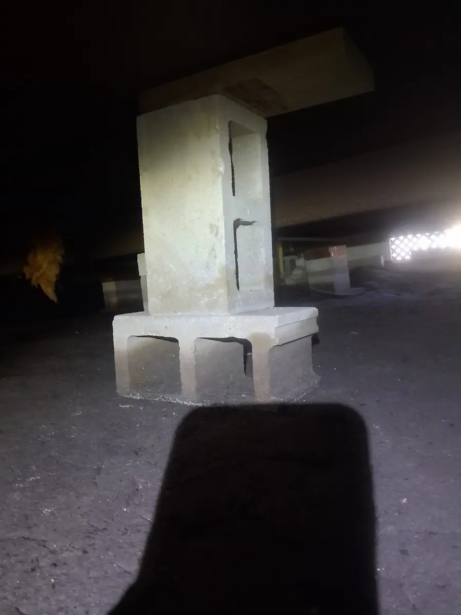 Concrete block pier with a cap block set on a pad under a manufactured home