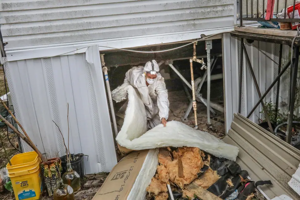 Old belly material and insulation coming out from under a mobile home in Spring Hill, FL