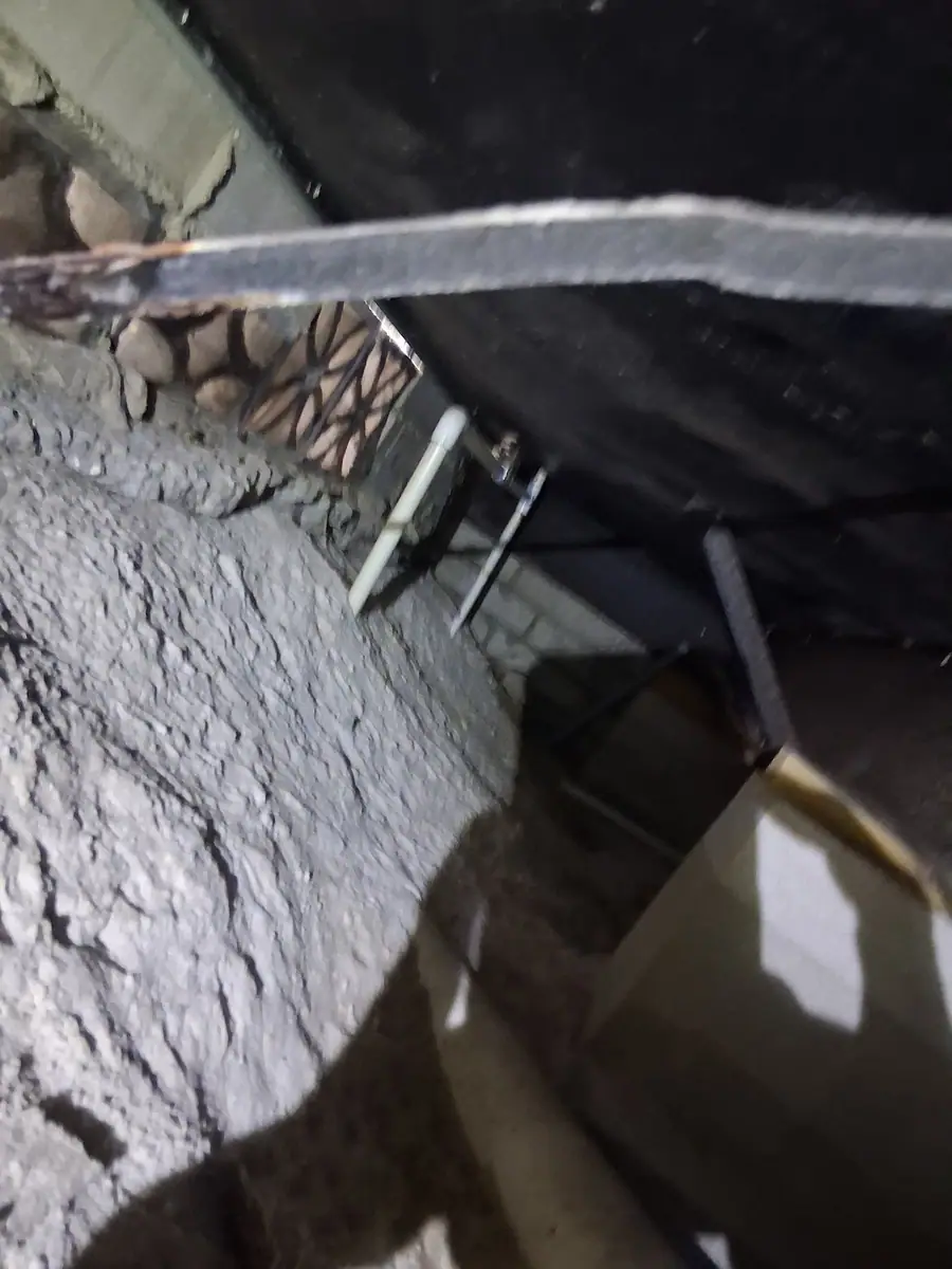Sagging belly over bare sandy soil under a manufactured home
