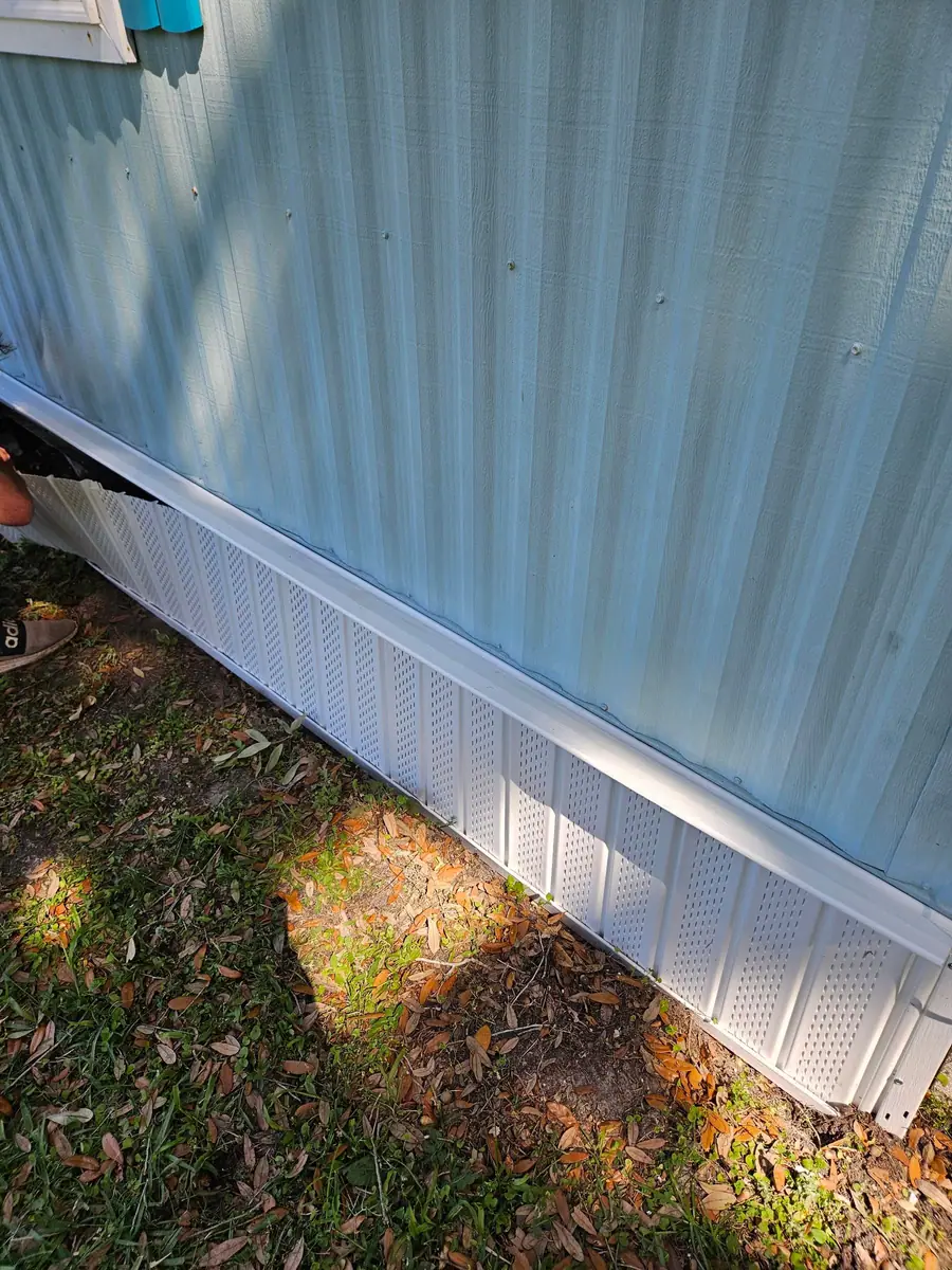 White vented skirting along a blue manufactured home