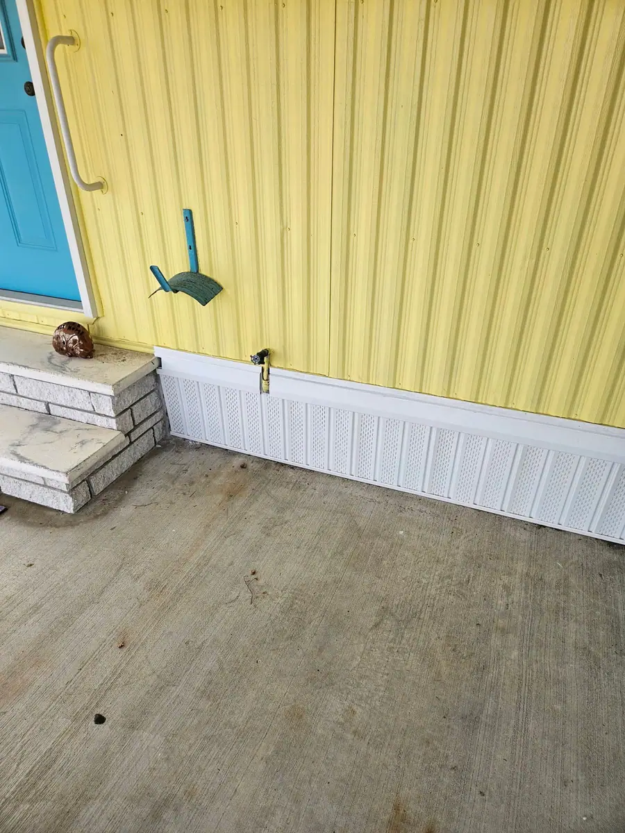 Finished white vented skirting on a yellow manufactured home in Spring Hill, FL