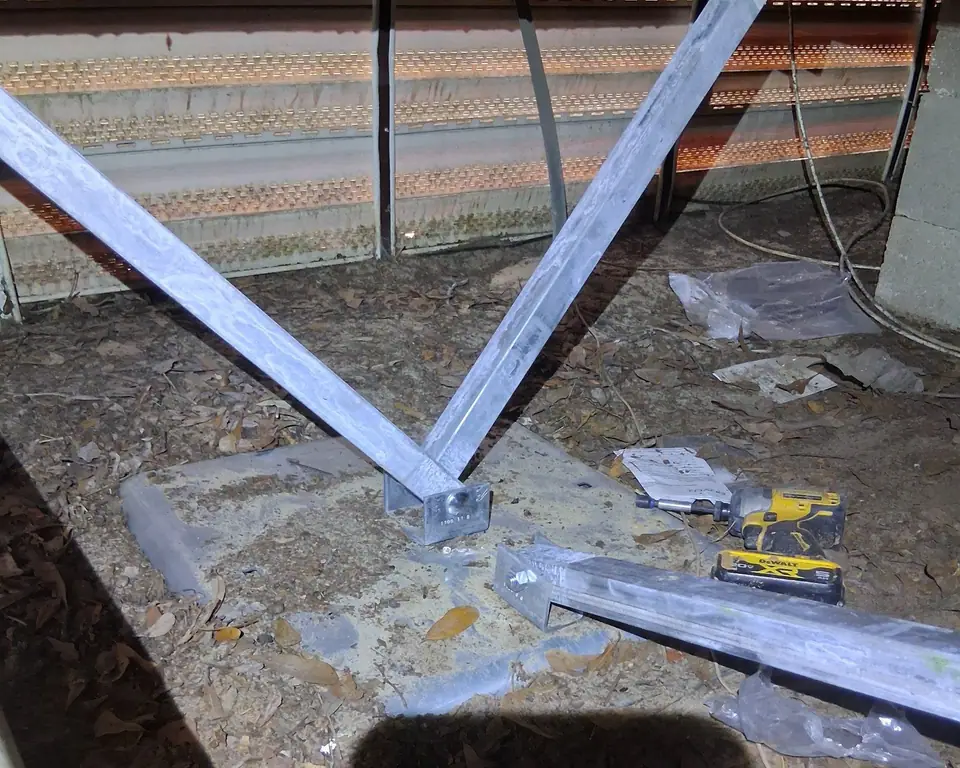 Steel struts fastened to a ground pan under a manufactured home during an install