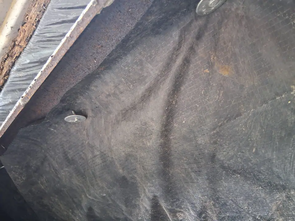 New vapor barrier stretched and fastened under a manufactured home